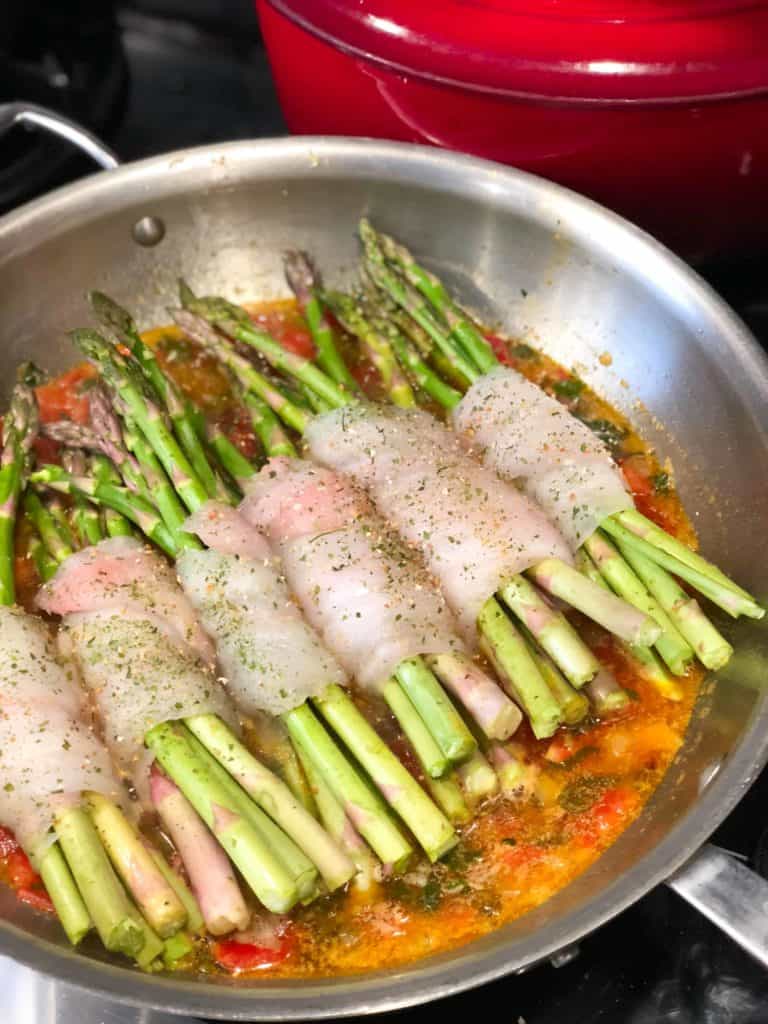 poaching fish and asparagus in tomato sauce