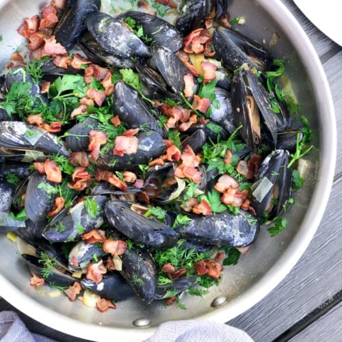 steamed mussels in pan with leeks and bacon