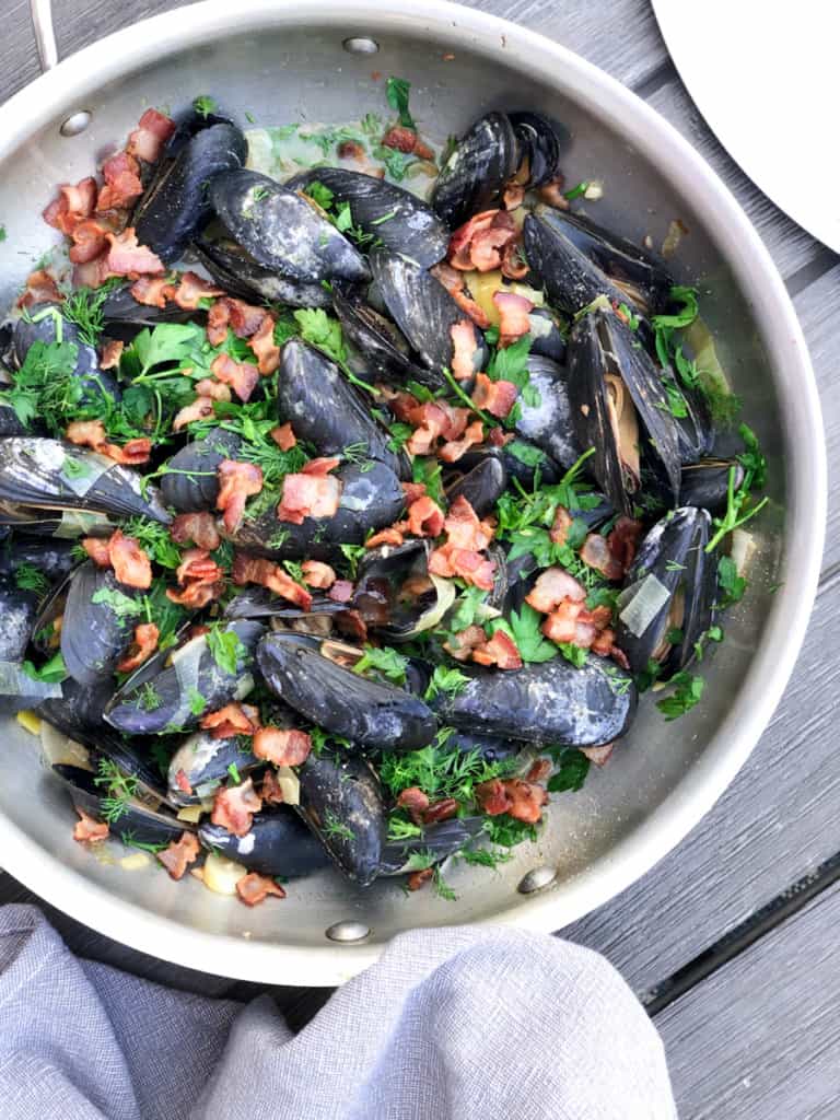 steamed mussels in pan with leeks and bacon