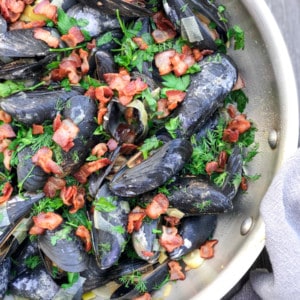 mussels cooked in white wine sauce with fresh herbs and bacon