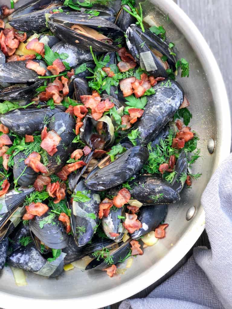 mussels cooked in white wine sauce with fresh herbs and bacon
