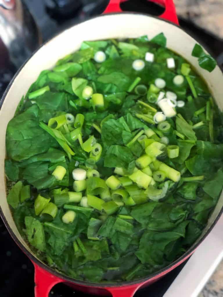 adding spinach to green borscht