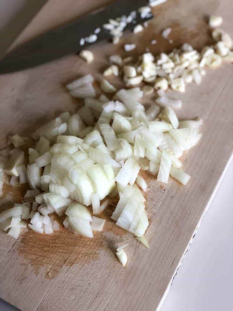 diced onion on a cutting board with knife