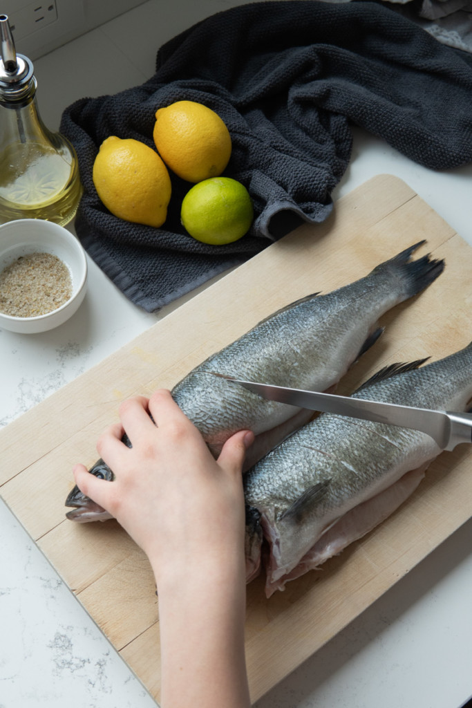 making incisions in the whole fish with a knife 