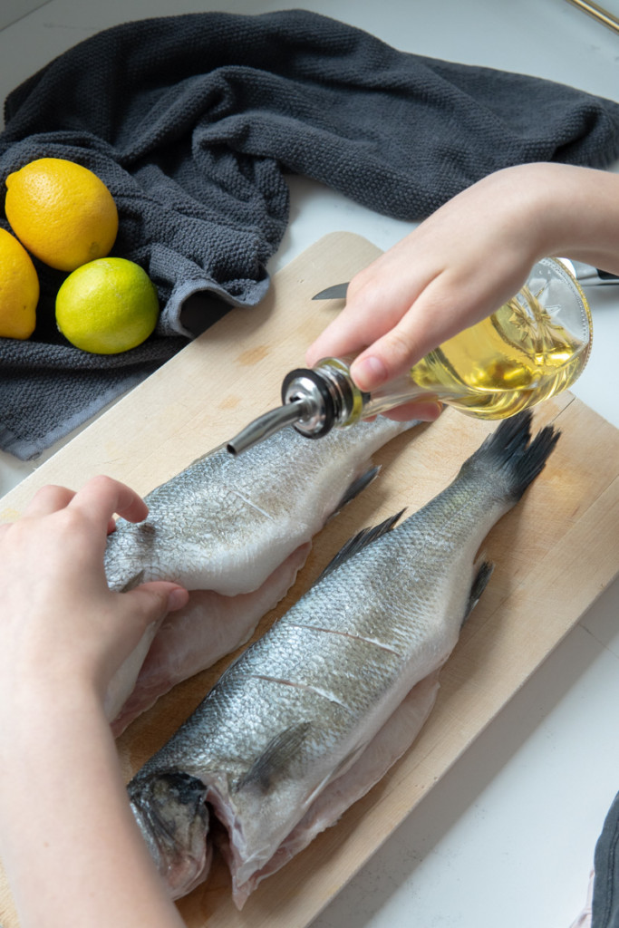 rubbing olive oil on fish 