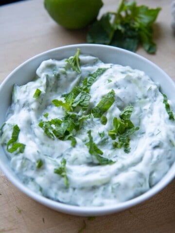 vegan tzatziki sauce in bowl with mint on top