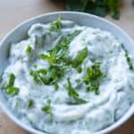 vegan tzatziki sauce in bowl with mint on top