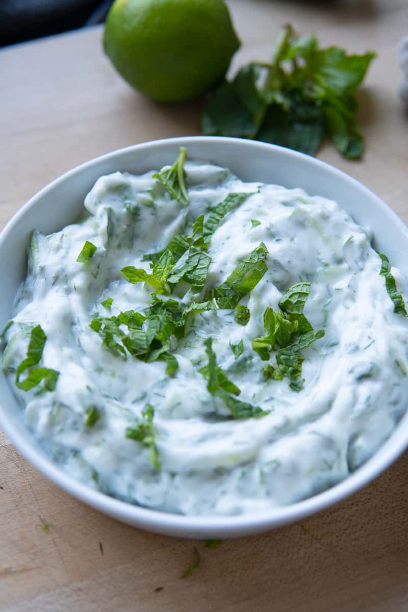 vegan tzatziki sauce in small bowl with mint on top