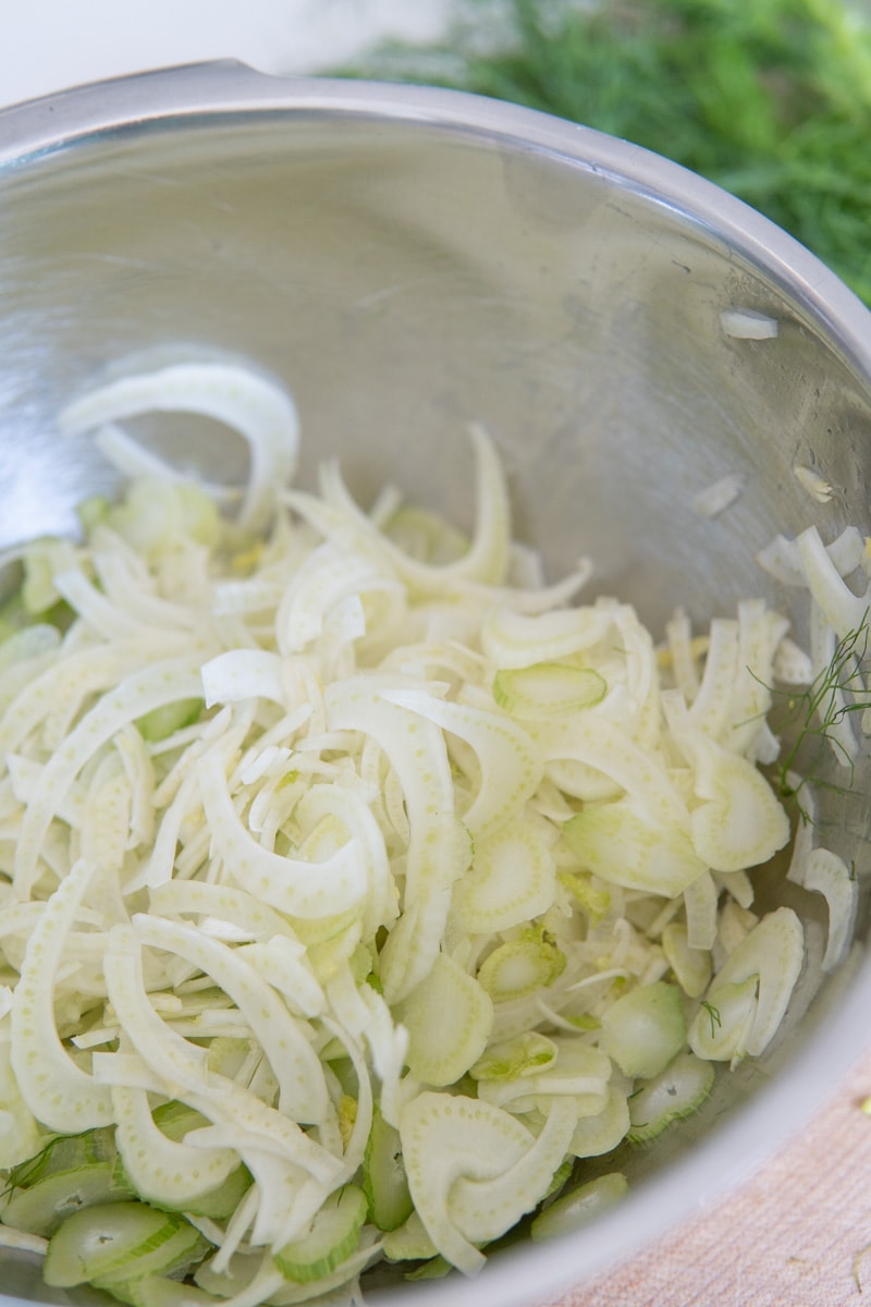 Shaved fennel in a mixing bowl.