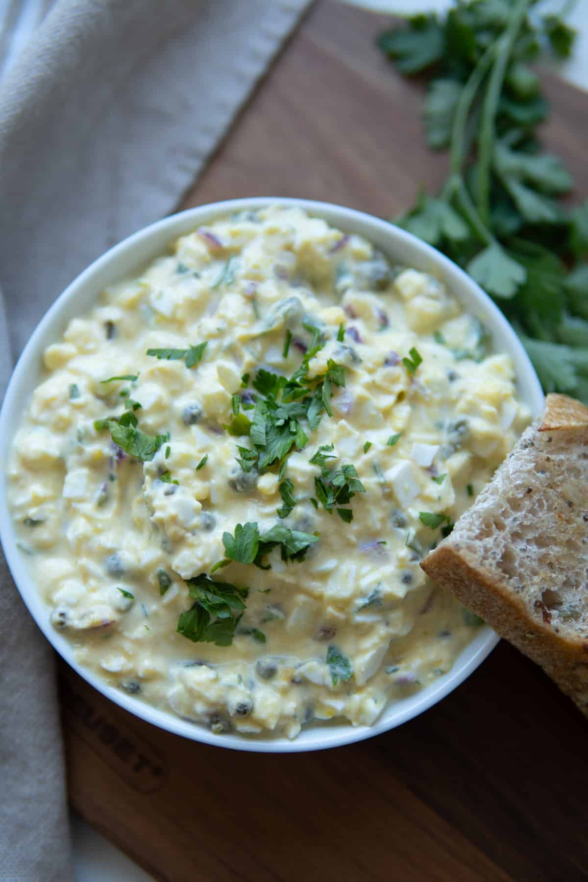 No mayo egg salad in a bowl topped with chopped herbs.