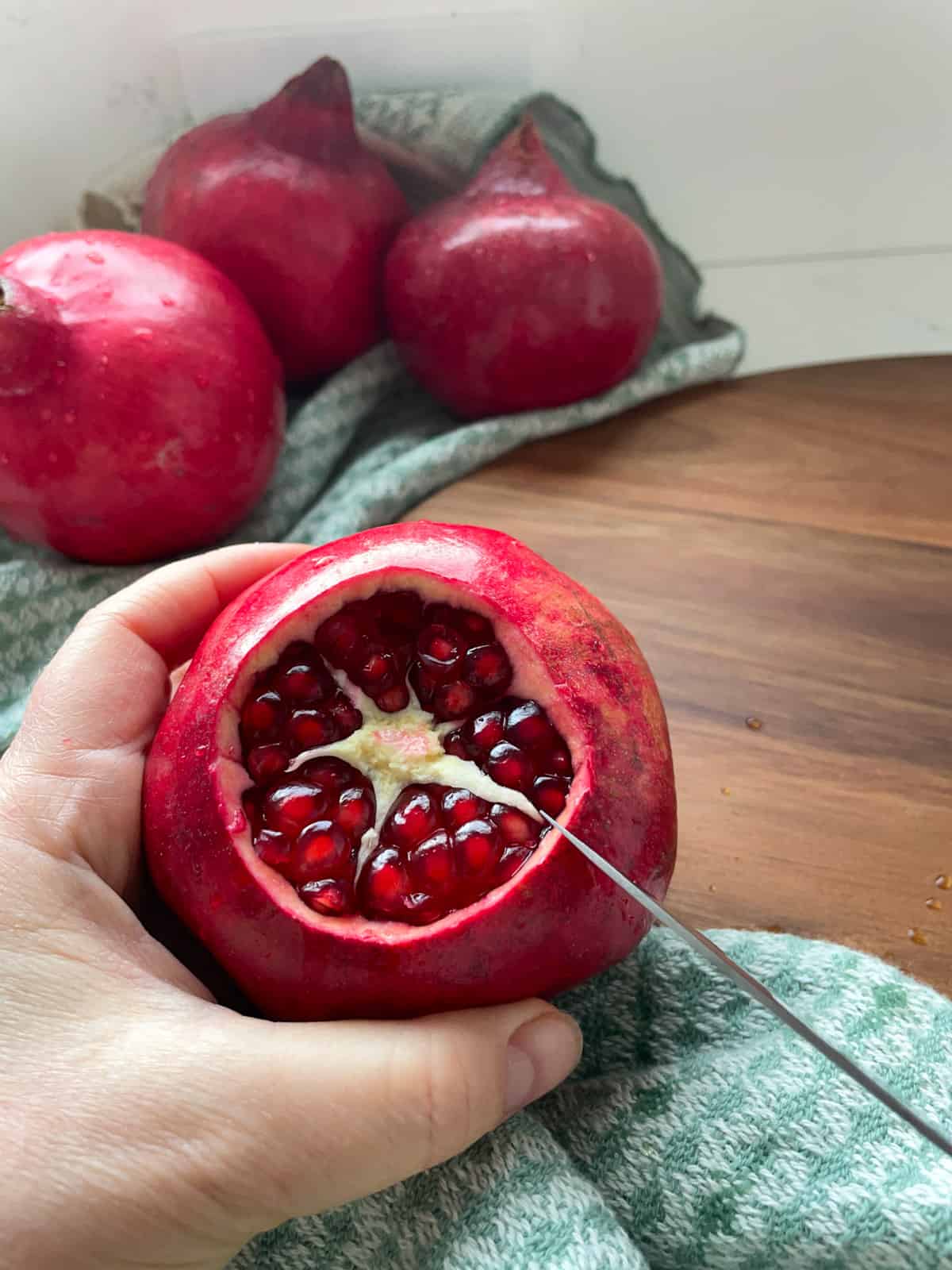 A pomegranate with the top removed showing the arils inside.
