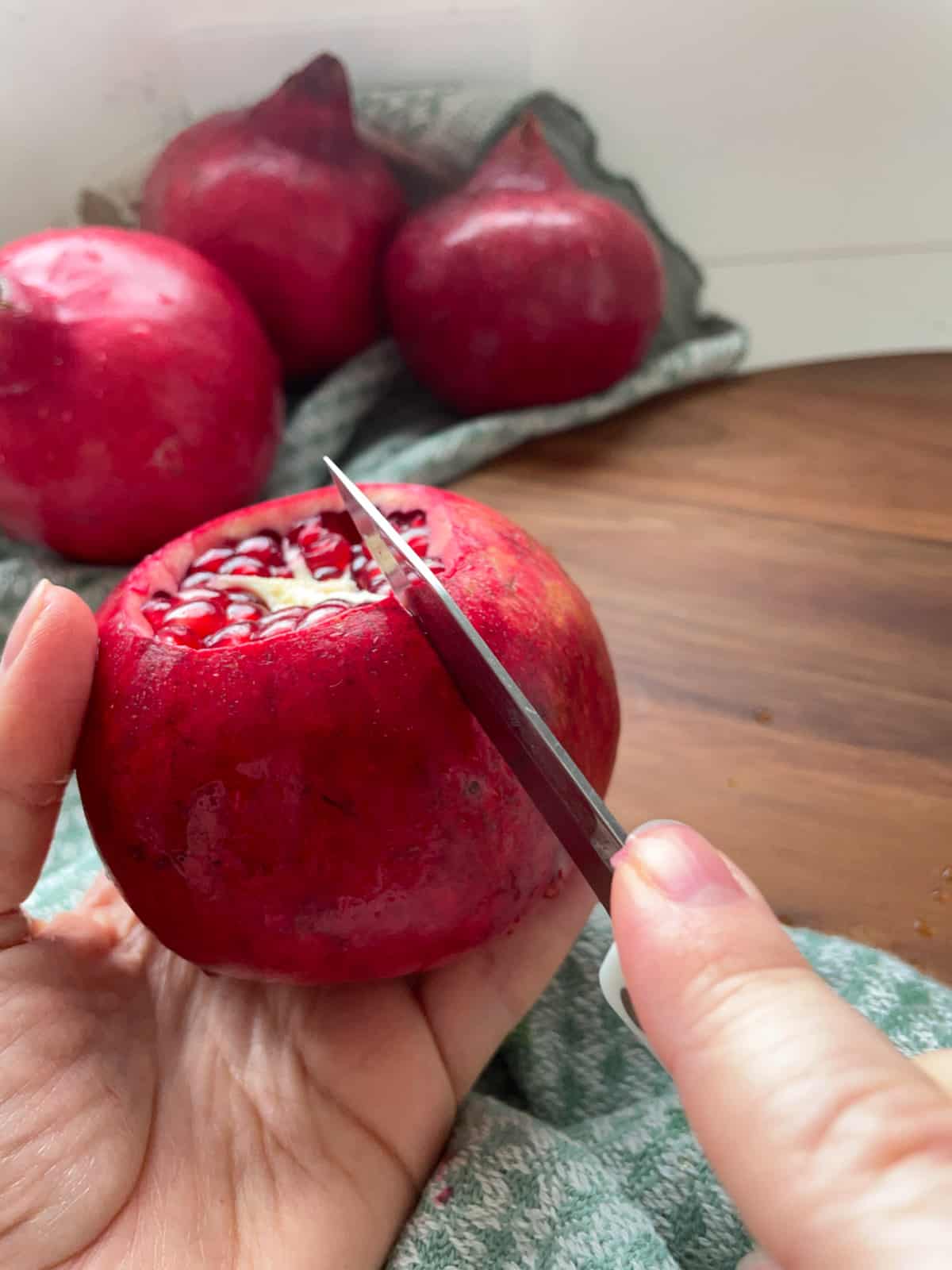 Making cuts along the outside of a pomegranate.