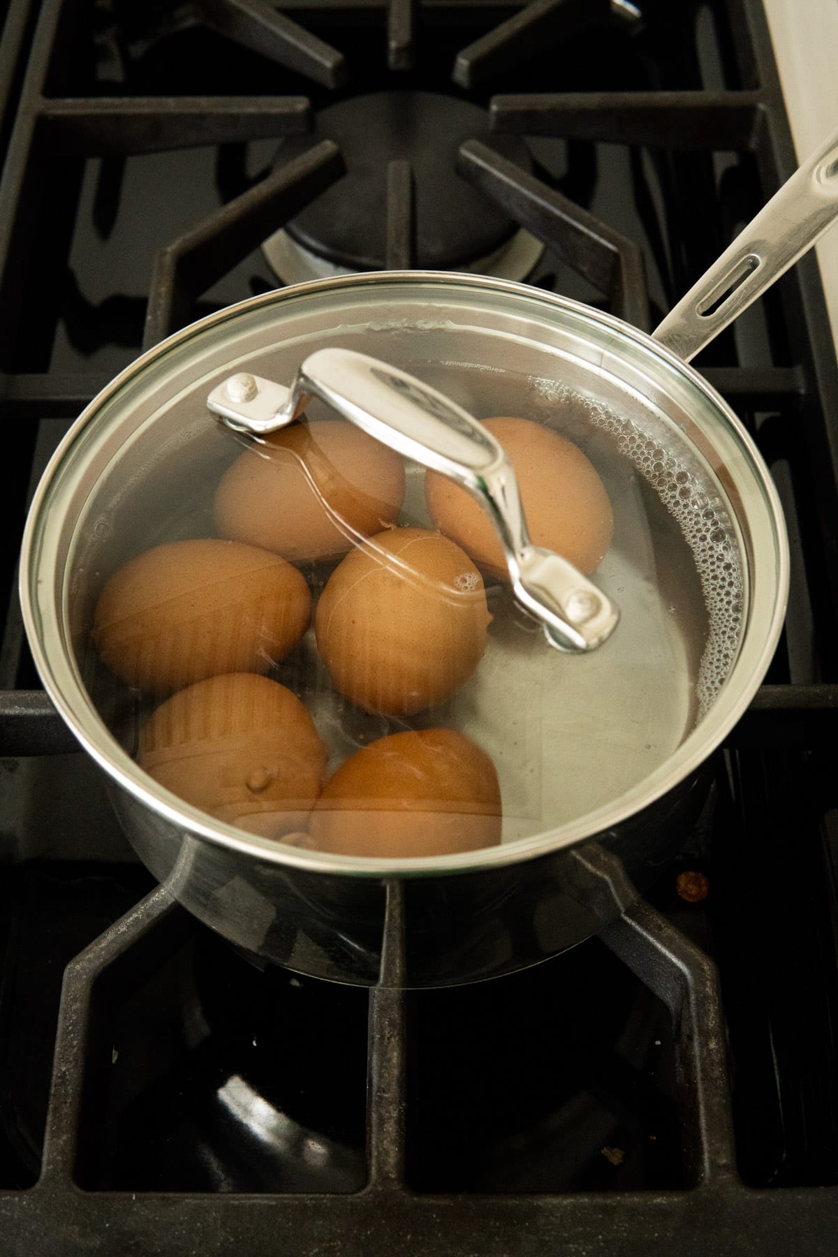 Eggs in hot water in a covered pot.