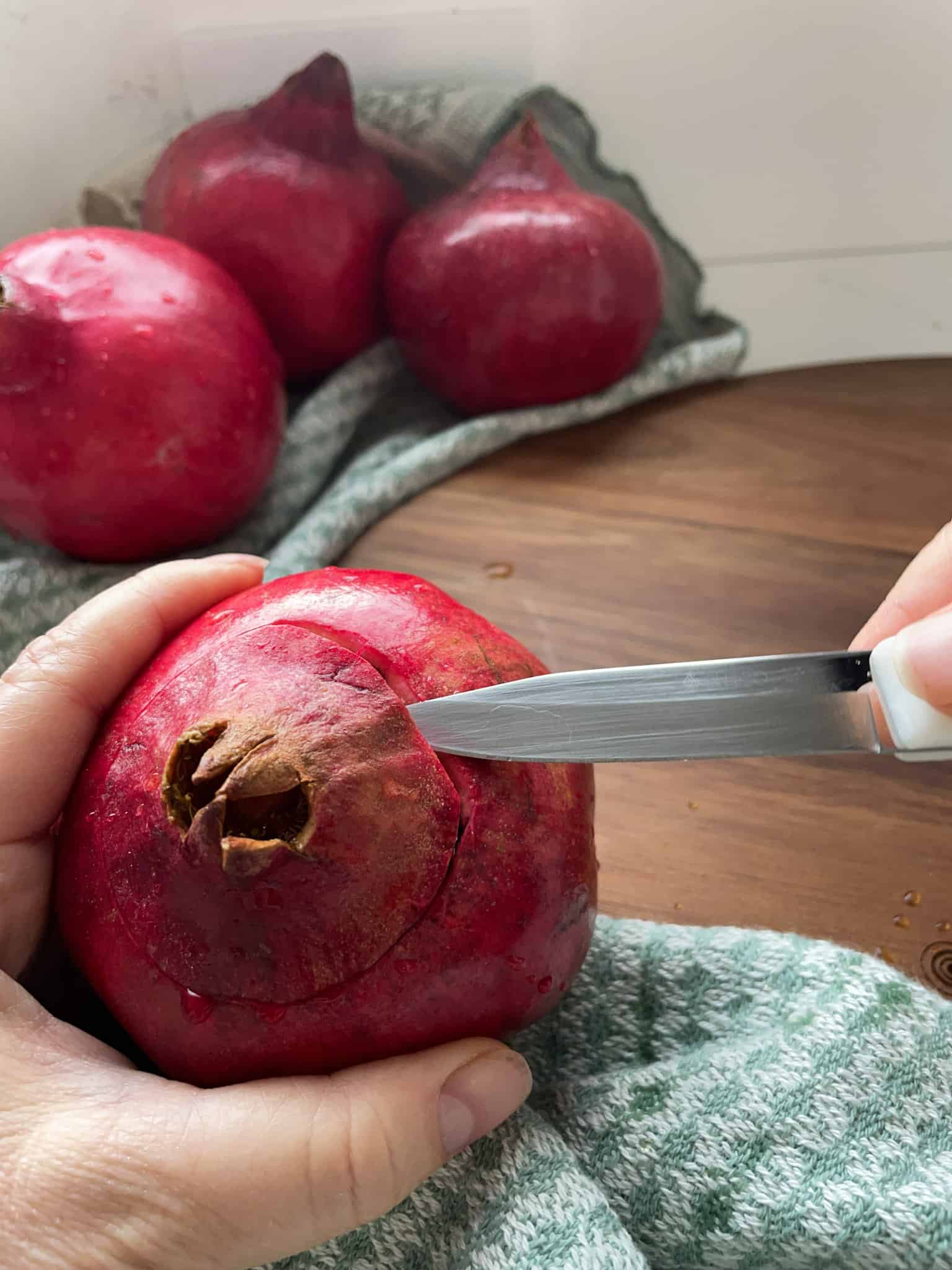 A pomegranate with the top cut out with a paring knife 