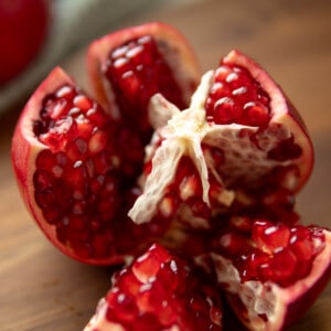 A cut open pomegranate revealing the seeds and inner segments.