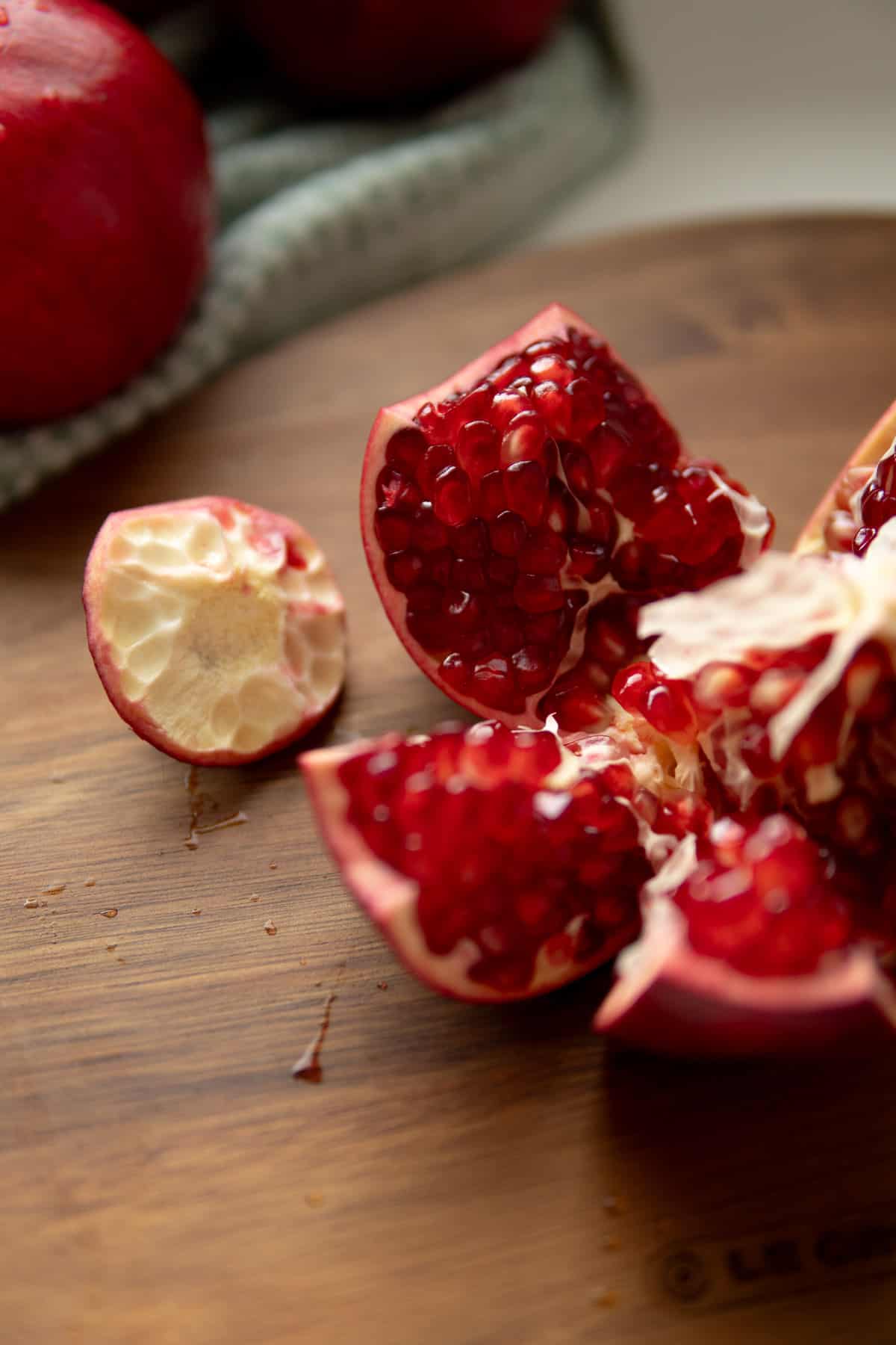 pomegranate opened into segments on a wooden board