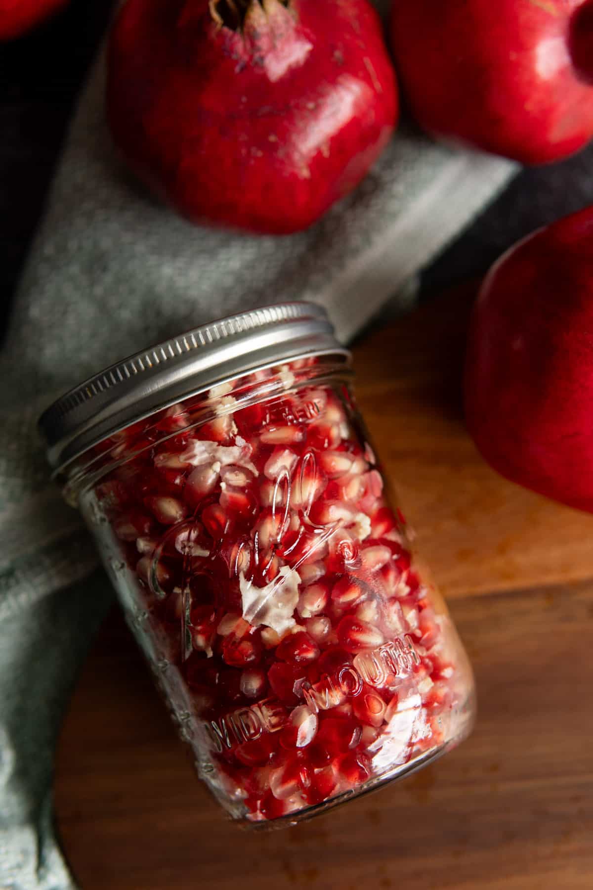 clean pomegranate seeds inside a clear wide mouth mason jar