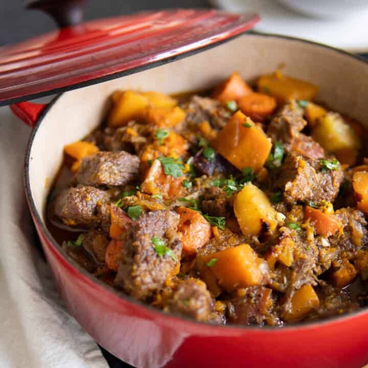 Gluten free beef stew in a red dutch oven.