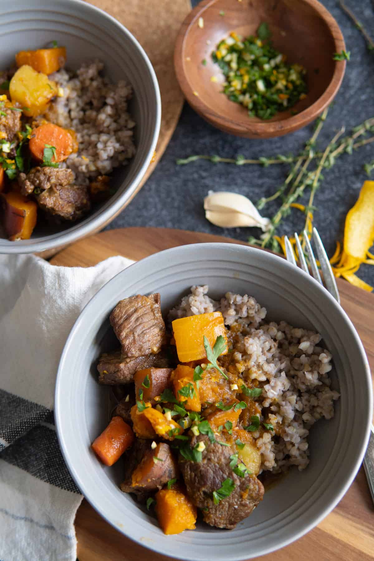 Two bowls of beef stew served over buckwheat. 