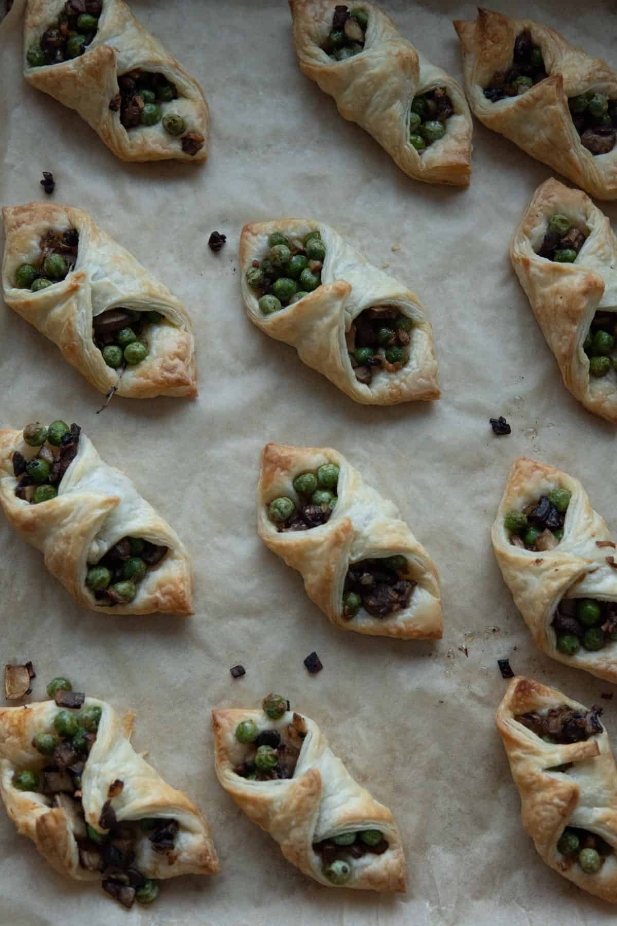 Mushroom and pea puff pastry bites on a baking sheet.