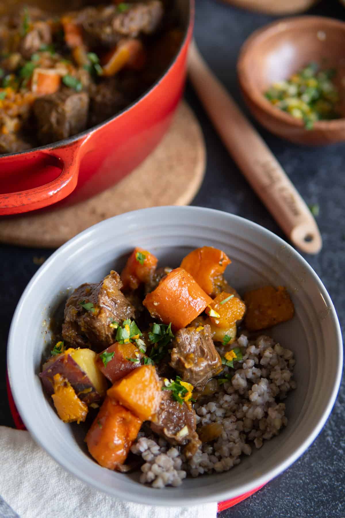 bowl of beef stew with carrots and squash over buckwheat. 