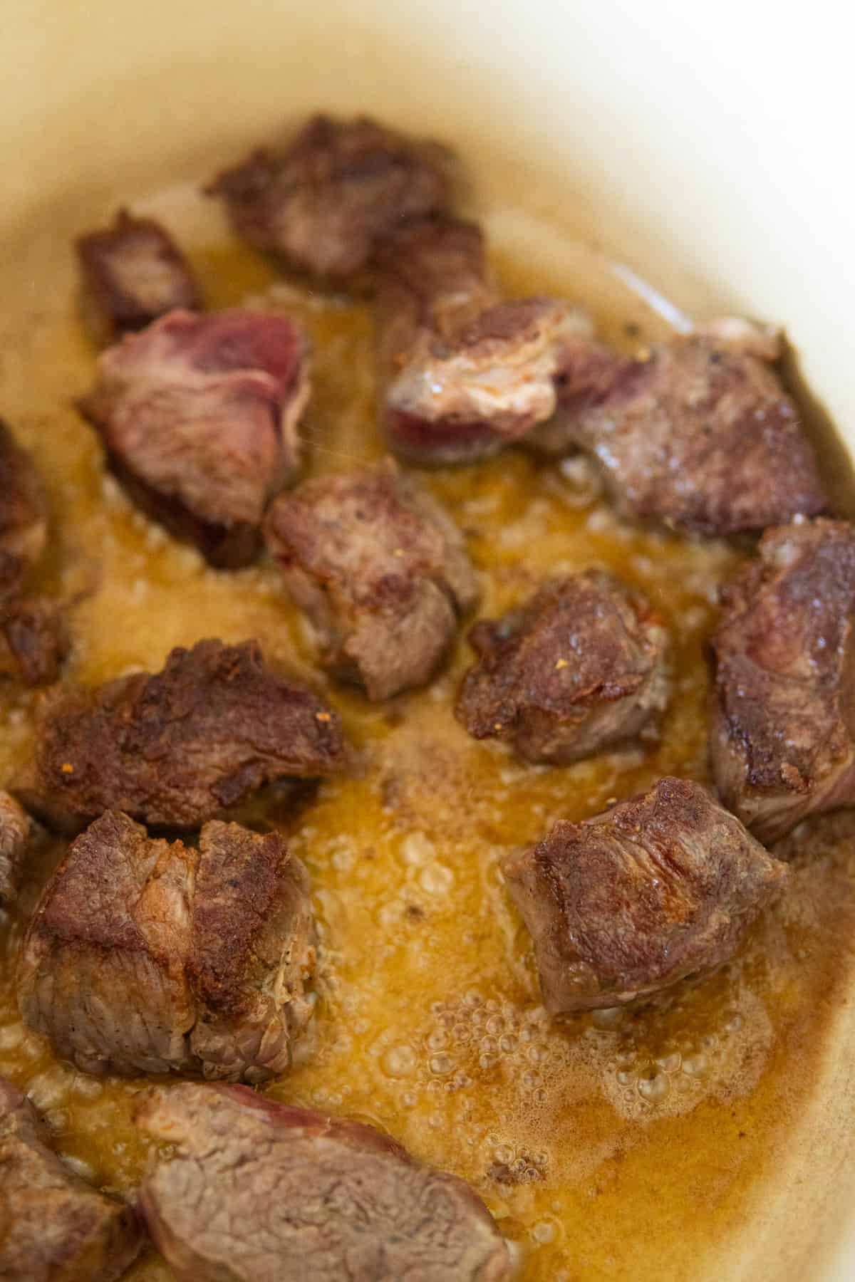 Browning beef stew chunks in pan 