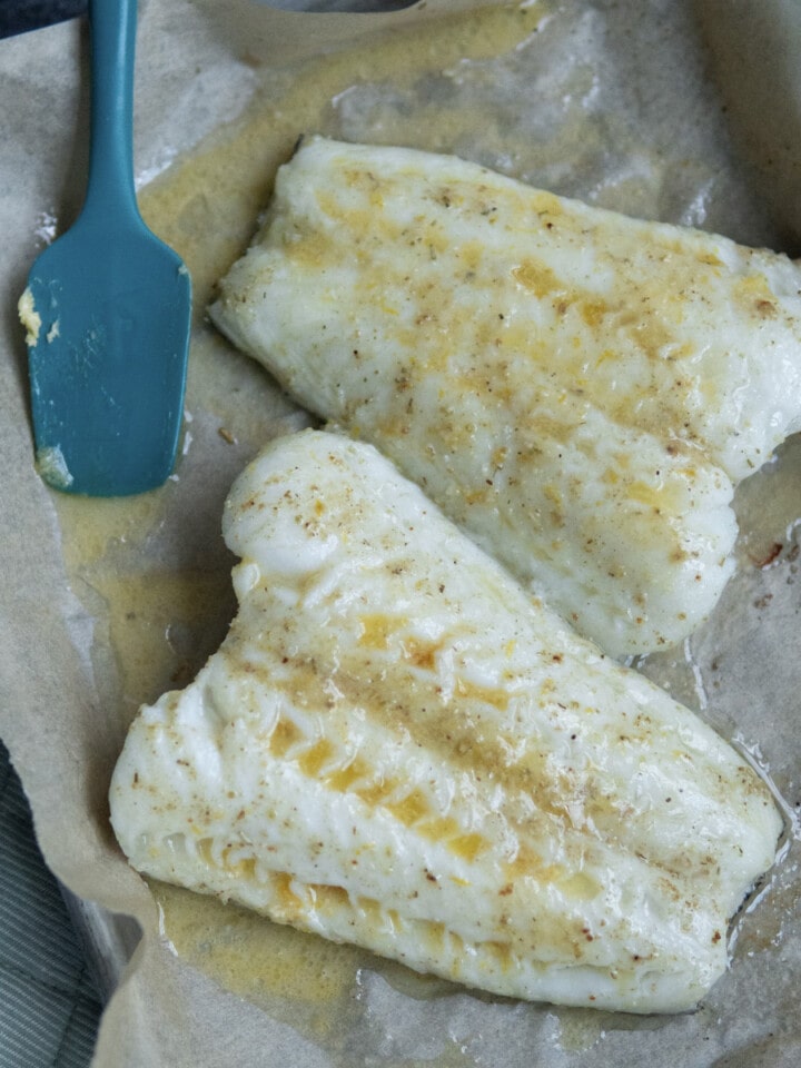 fish with melted compound butter on top of parchment paper