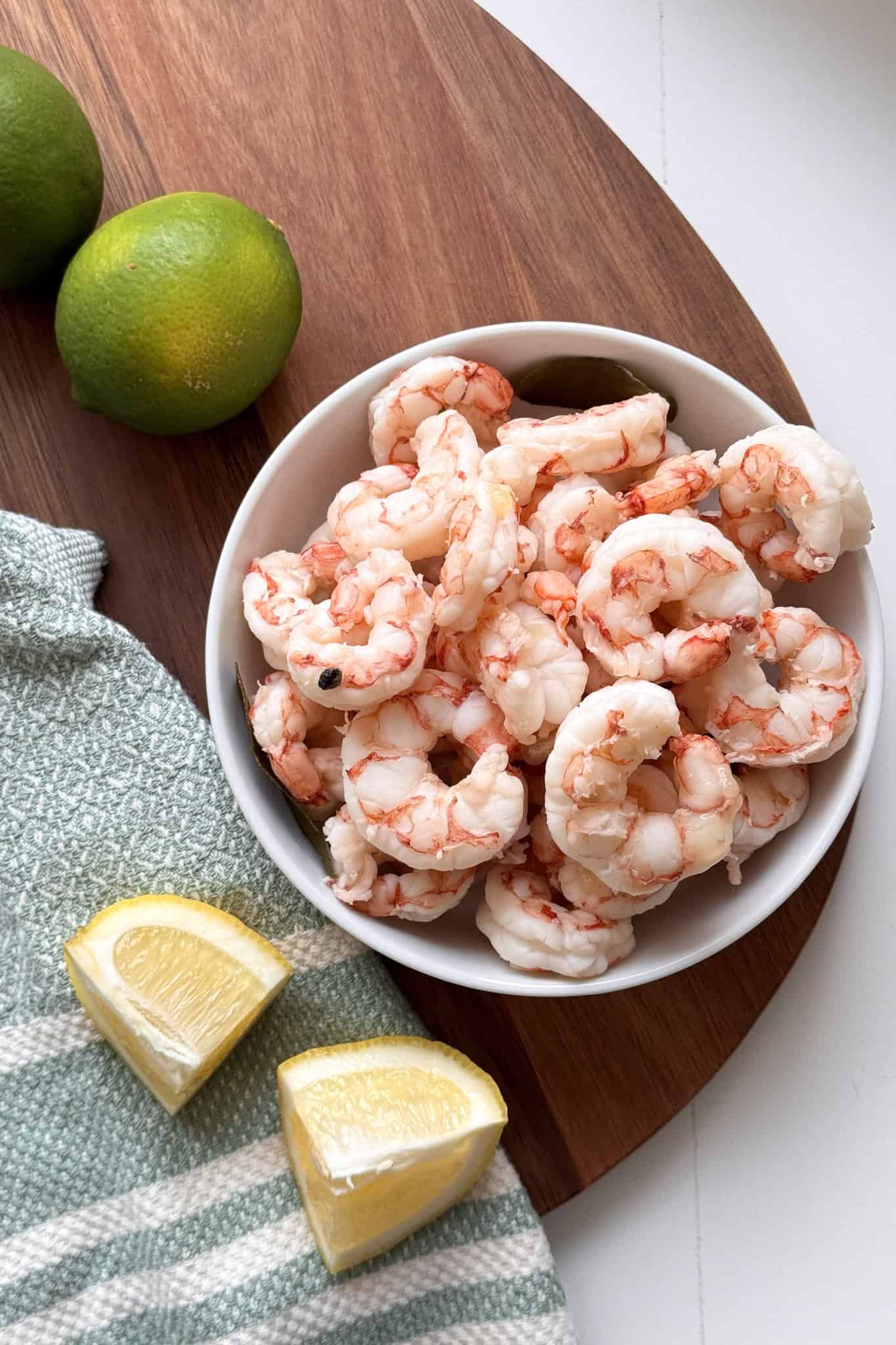 boiled shrimp in bowl with lemons and limes to the side