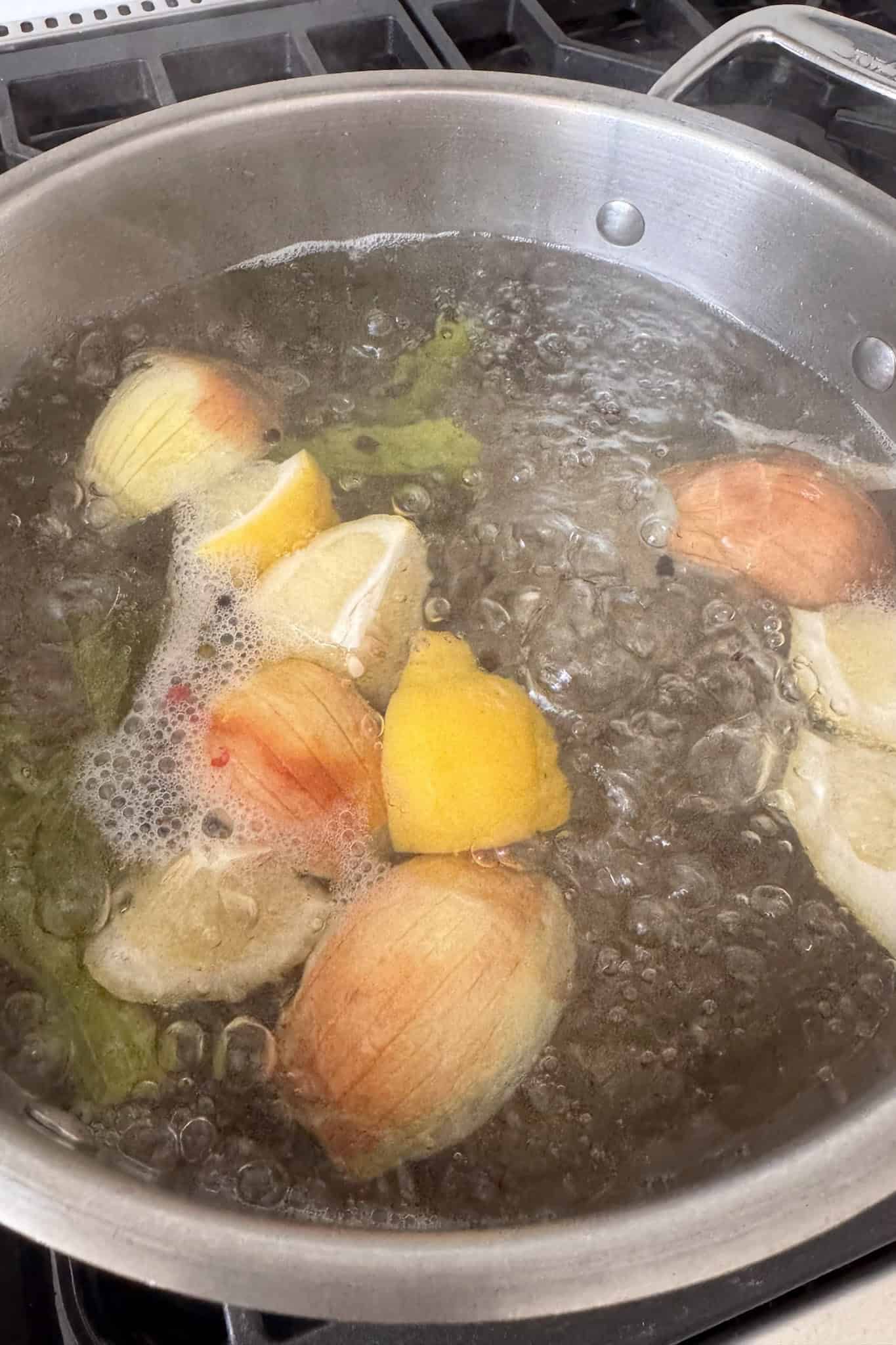 pot of water with boiled water and onions and lemons