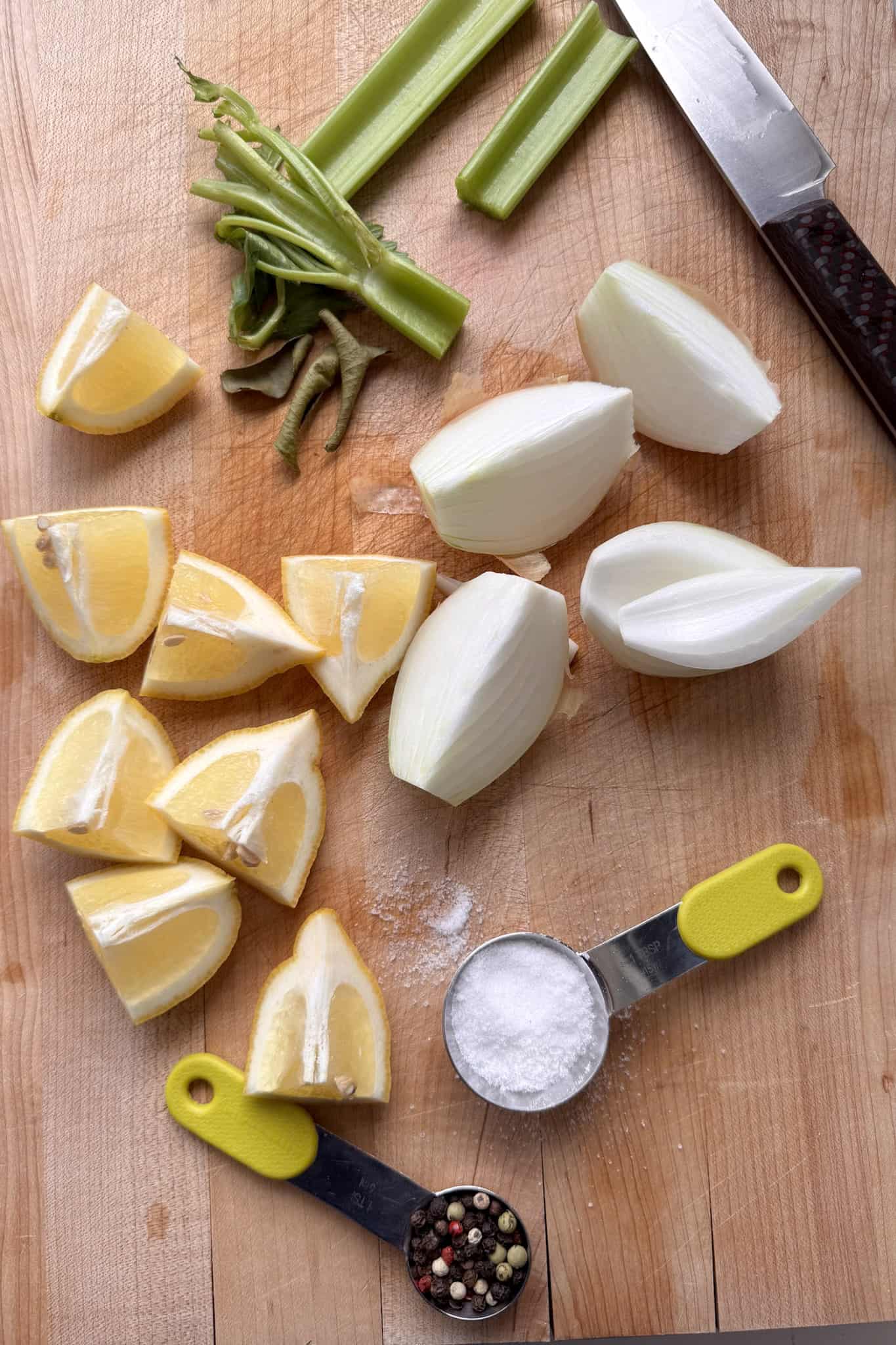 cut up celery, onion, and lemon into wedges on cutting board