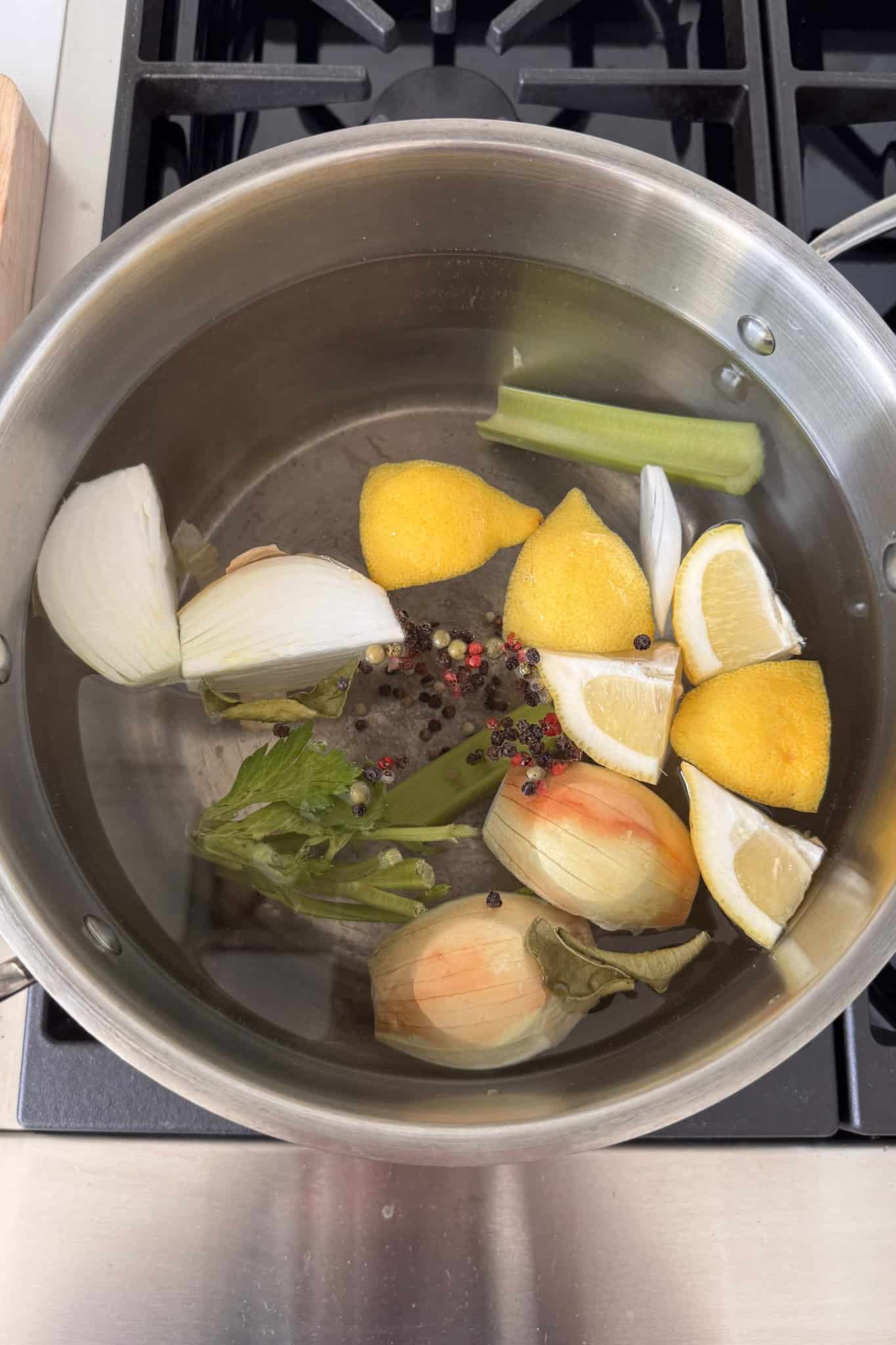pot with water, lemons, onion, celery