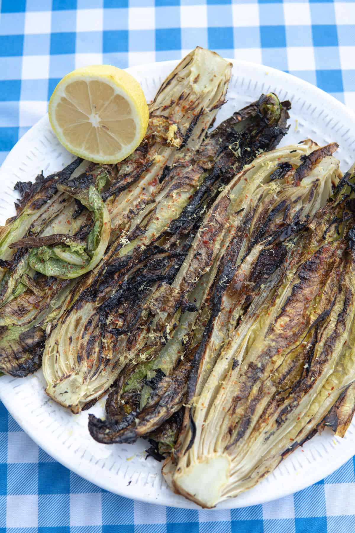 romaine grilled on a plate with a side of lemon. 