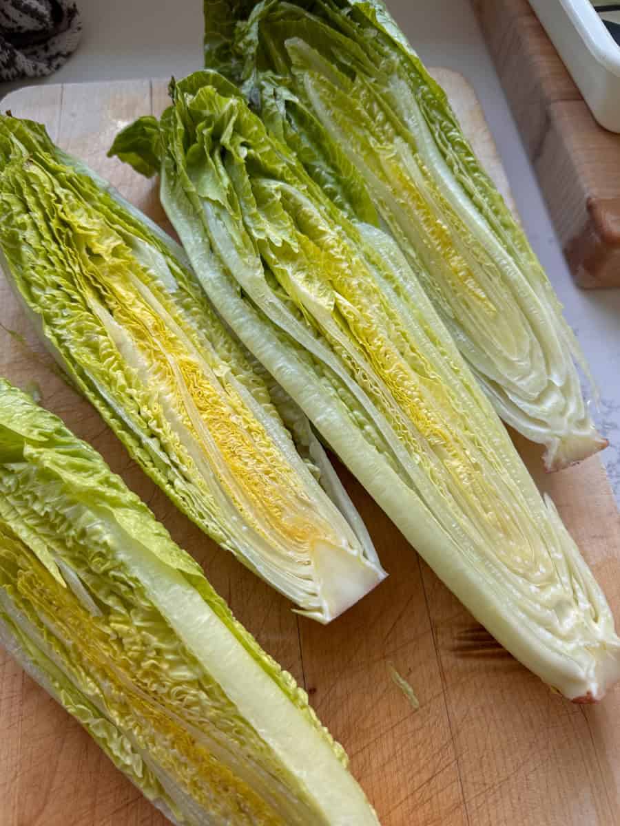 romaine hearts cut in half on cutting board 