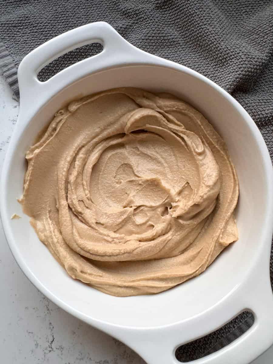 hummus plated in a white bowl with swoosh design