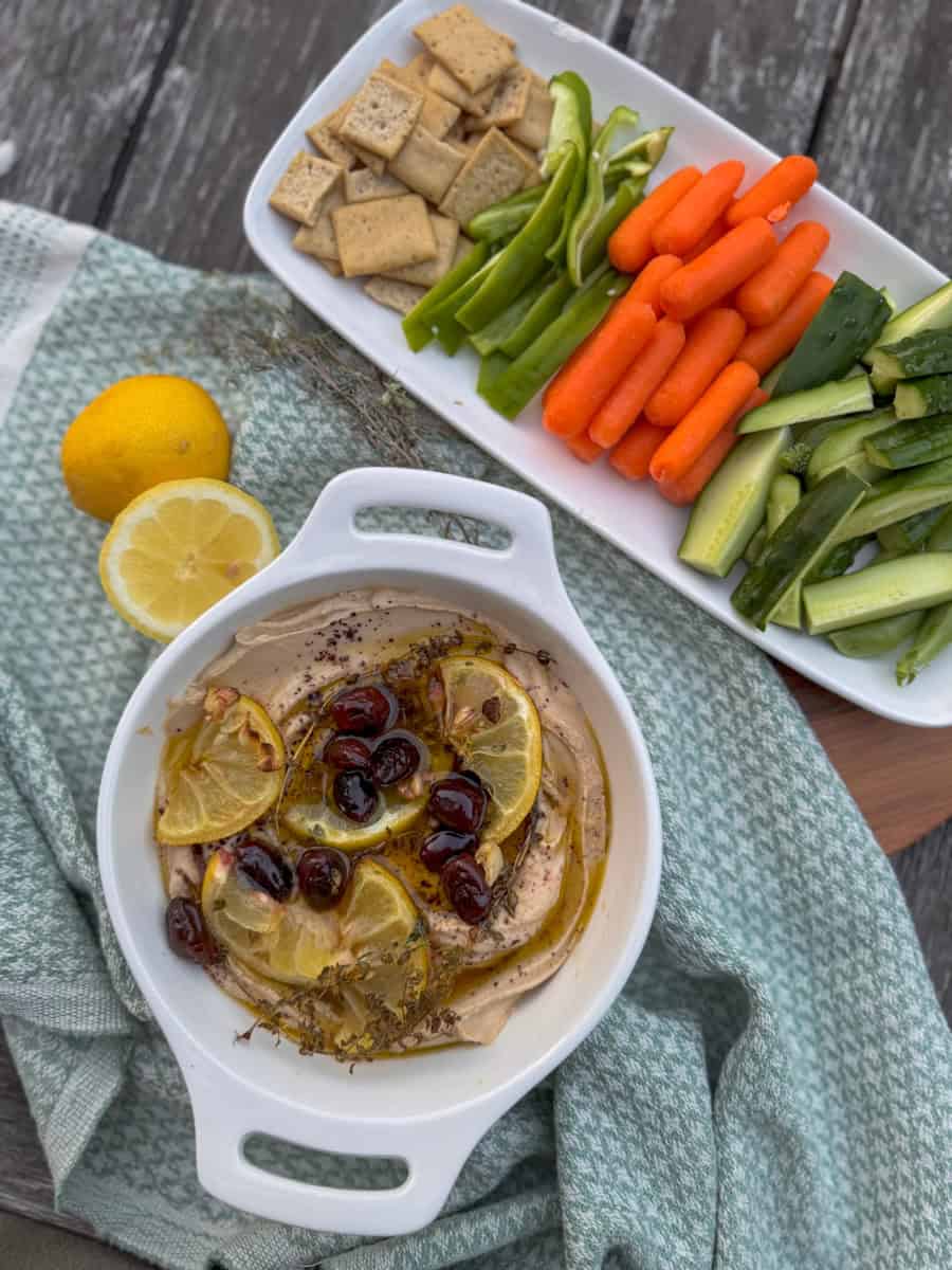 bowl of hummus and a platter of fresh vegetables for dipping 