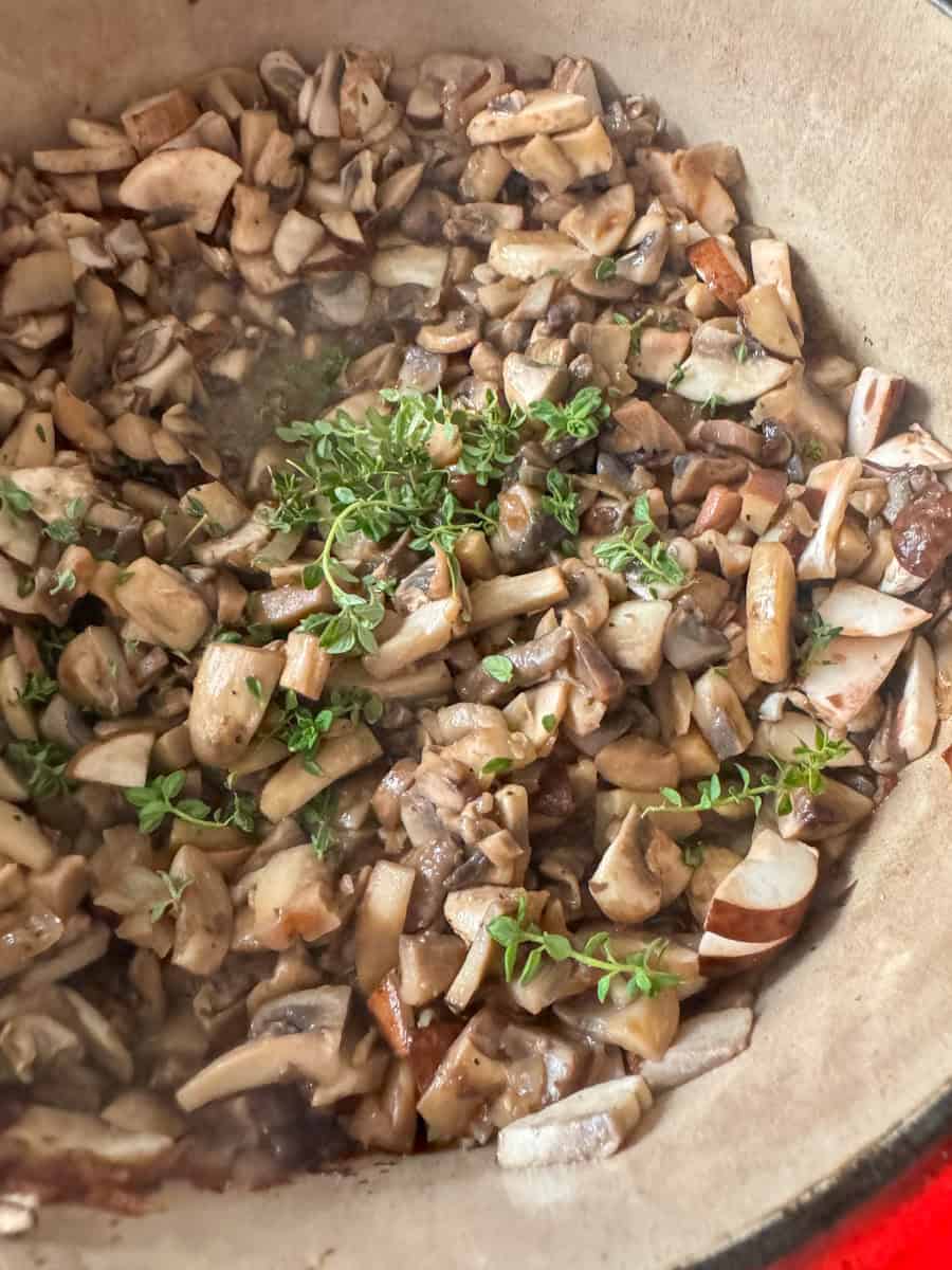 mushrooms sauted in a dutch oven with thyme