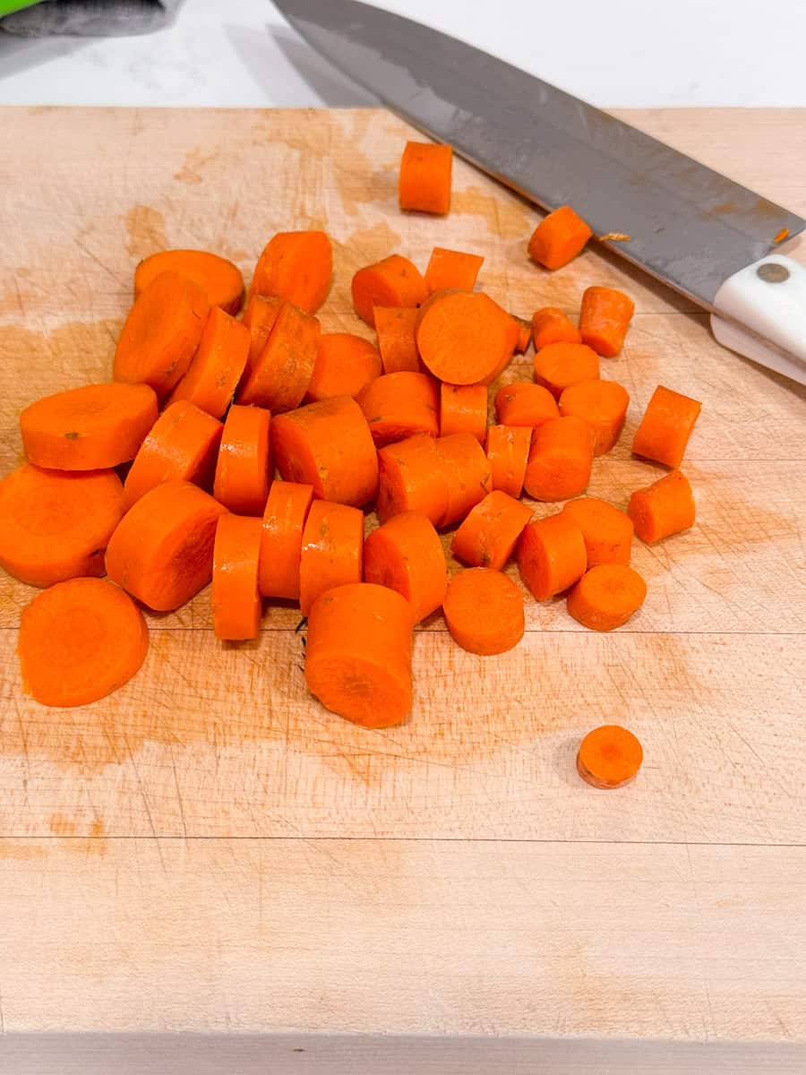 carrots cut up on a cutting board with knife on side 