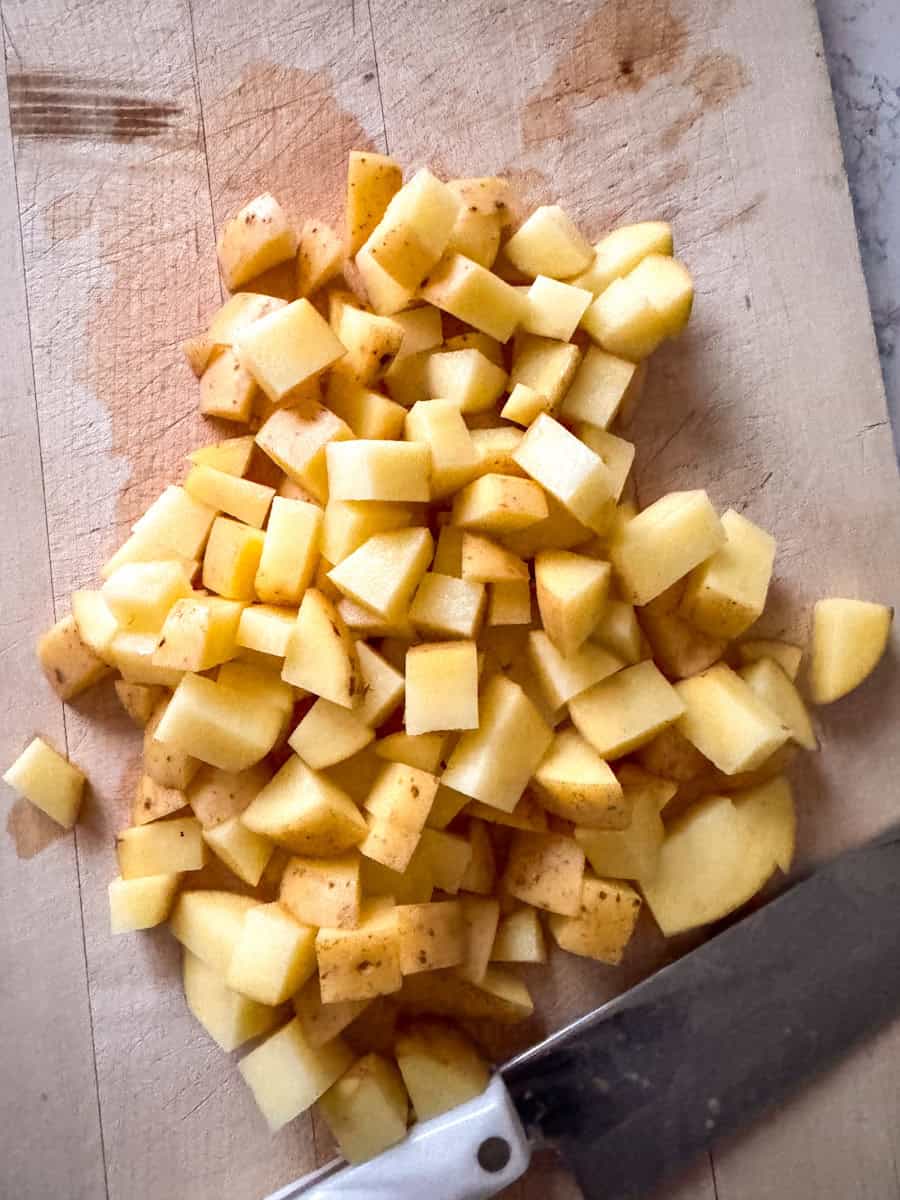 potatoes cut up into cubes on a chopping board. 