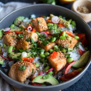 bowl of salmon chunks over rice and veggies