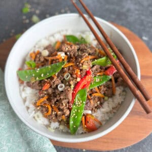 bowl with rice and ground beef with chopsticks