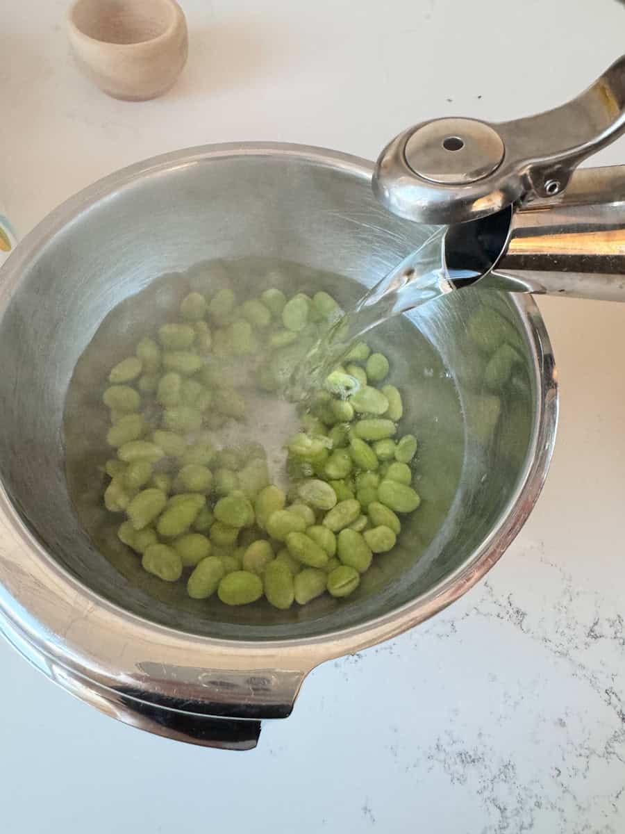 edamame in a bowl with hot water being poured over them