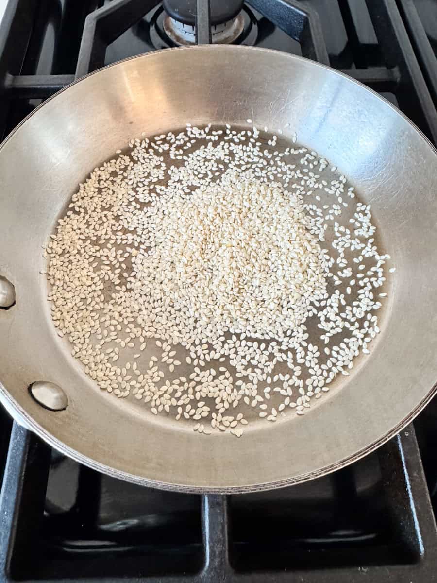 a stainless steel pan with sesame seeds 