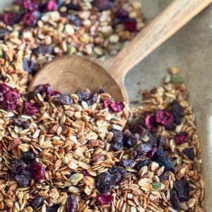 baking sheet with granola and wooden spoon