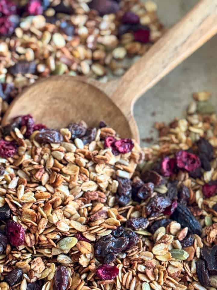 baking sheet with granola and wooden spoon