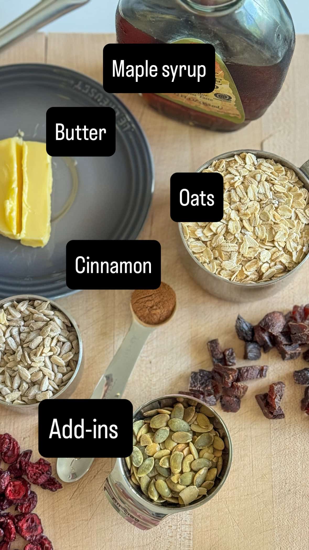 ingredients on table for granola in measuring cups and labels on top. 