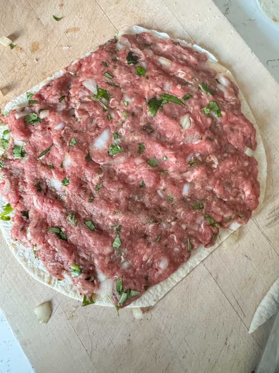 wrap on board with meat mixture spread out
