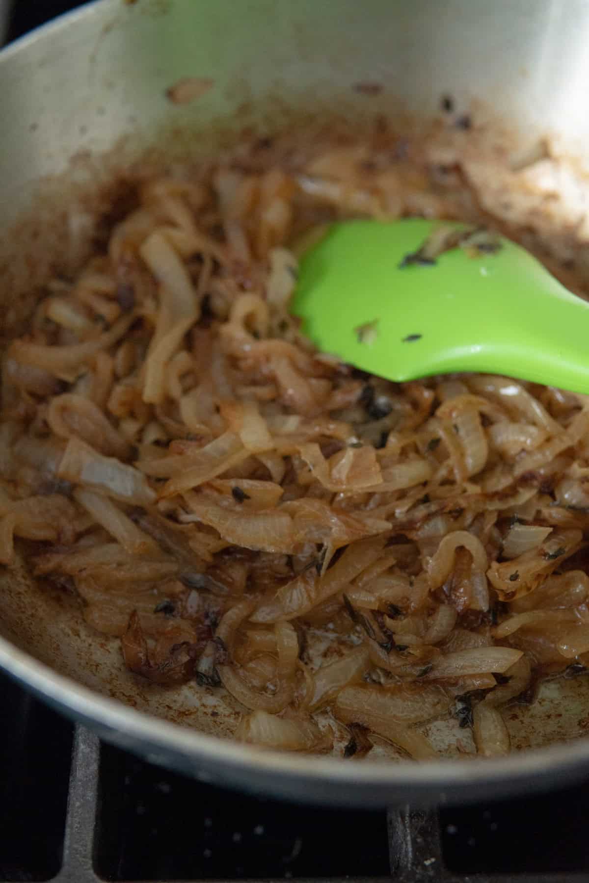 pan with caramelized onions and green spatula
