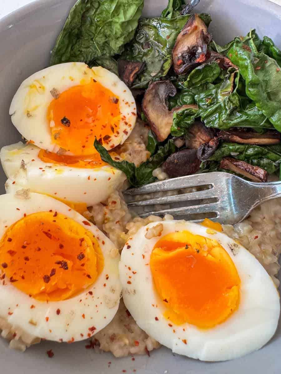 breakfast bowl with boiled eggs, oats, and kale.