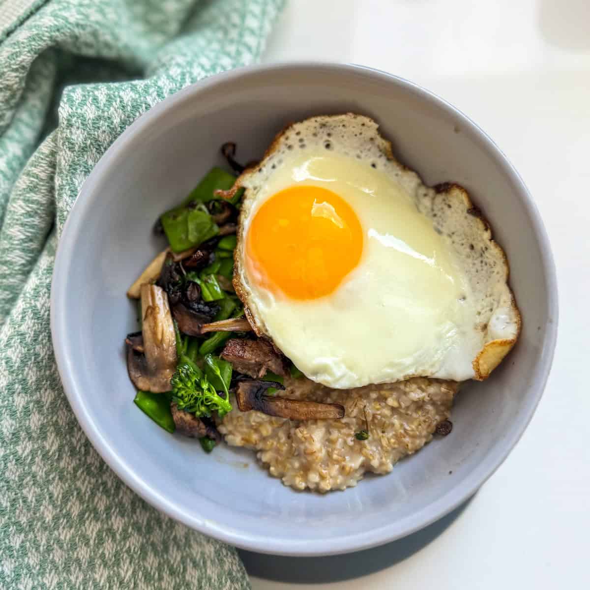 bowl with oats, sautéed veggies and egg 