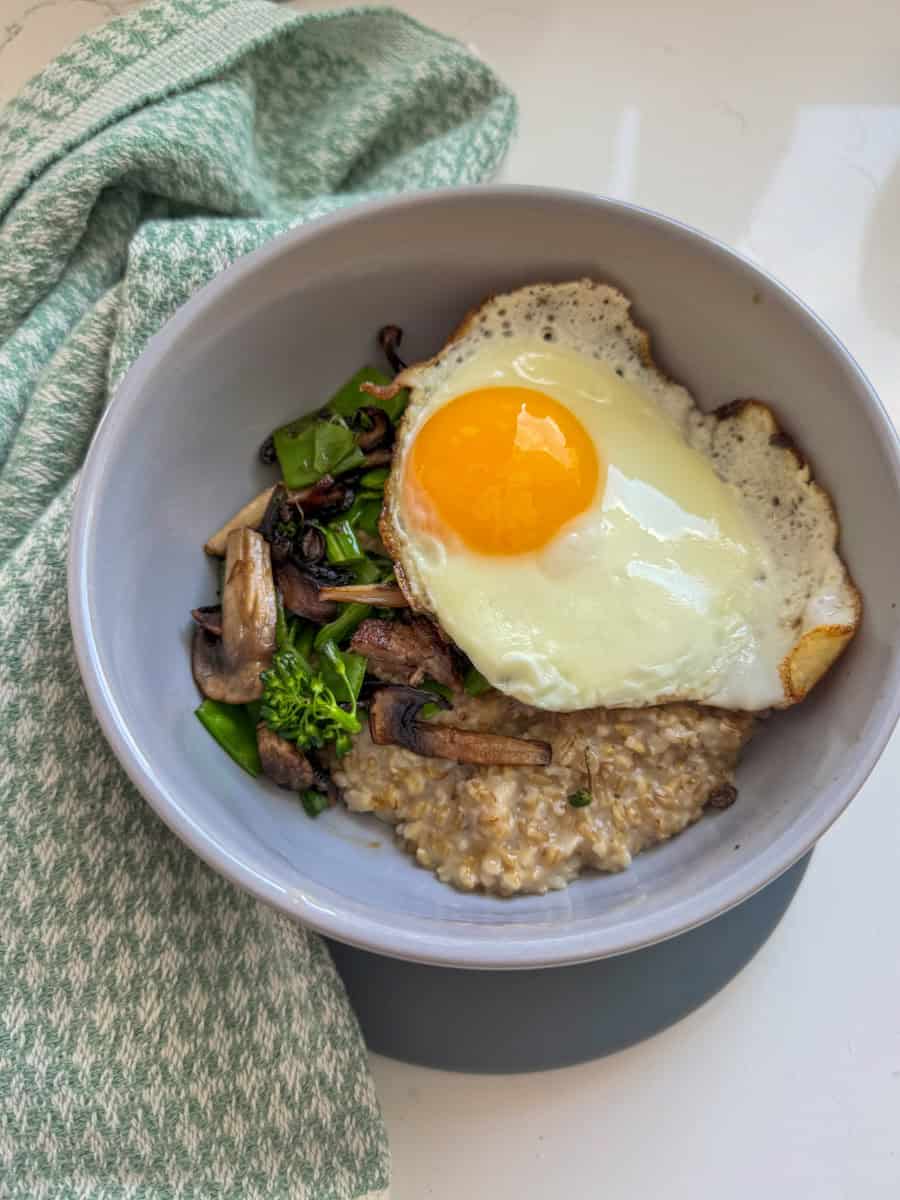bowl with steel cut oats, vegetables and sunny side egg. 